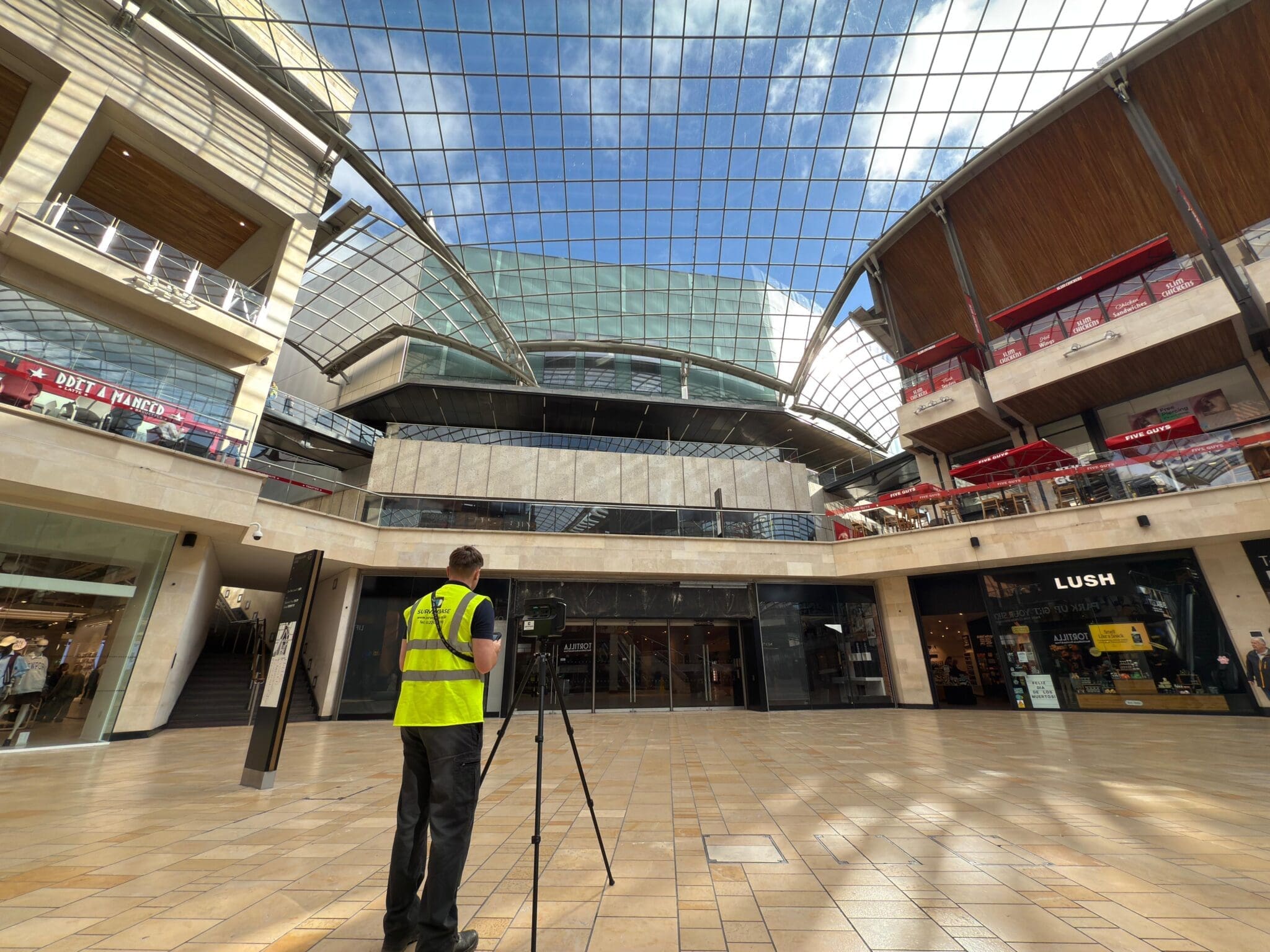 Surveyor using a Matterport camera in a shopping centre to capture a 360-degree digital survey of the property