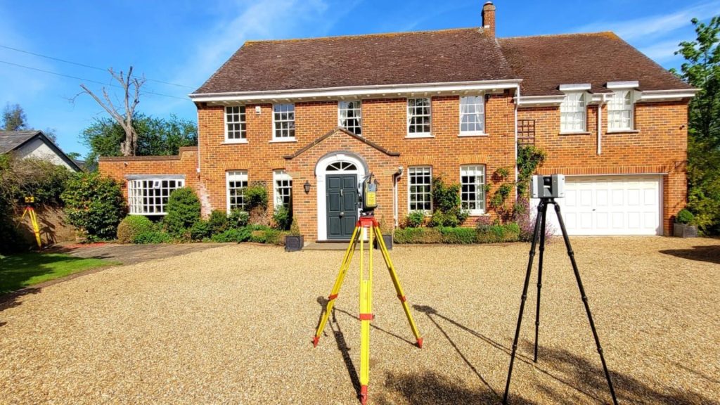 Surveying equipment positioned outside a residential property during a measured building and topographical survey in the UK.