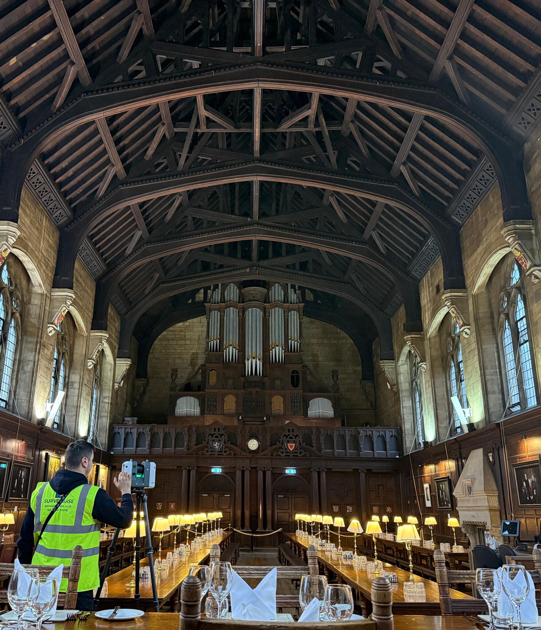 Surveyor inside a building operating a laser scanner for a measured building survey.